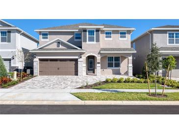 Charming two-story home with a paver driveway, a two car garage and nicely manicured lawn at 273 Auburn Ave, Kissimmee, FL 34747