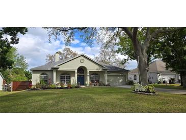 Charming single-story home with a well-manicured lawn and lush landscaping at 3887 Kingston Oaks Cv, Oviedo, FL 32765