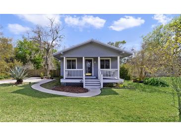 Charming single-story home featuring a cozy front porch and well-maintained lawn at 5990 Hibiscus Rd, Orlando, FL 32807