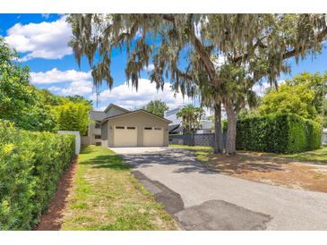 This property features a two car garage with a driveway and lush landscaping at 1213 Richmond Rd, Winter Park, FL 32789