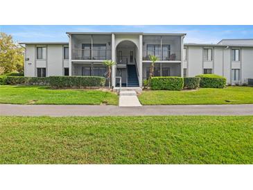 Exterior of a two-story condo building with well-maintained landscaping and screened-in balconies at 1317 S Pine Ridge Cir # 1317, Sanford, FL 32773