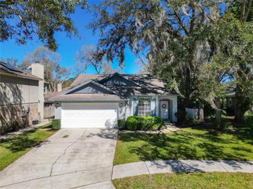 Charming single-story home featuring a well-maintained lawn and an attached two-car garage at 1525 Oakwood Ct, Apopka, FL 32703