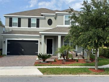 Charming two-story home with a well-manicured lawn, covered porch, and a two-car garage at 2403 Biscotto Cir, Davenport, FL 33897