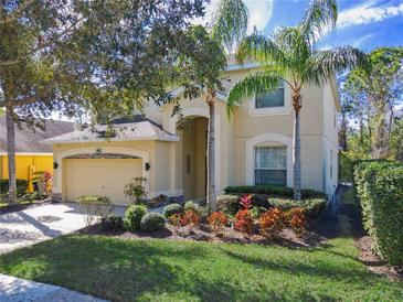 Charming two-story home featuring a well-manicured lawn, mature landscaping, and a welcoming entrance at 601 Orange Cosmos Blvd, Davenport, FL 33837