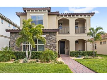 Charming two-story home features a stone facade, stucco accents, and a manicured lawn with tropical landscaping at 10236 Beechwood Ln, Orlando, FL 32832