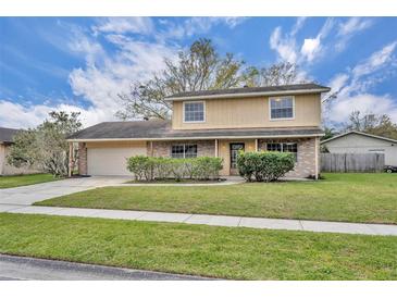 Charming two-story home featuring a brick facade, well-manicured lawn, and attached garage at 124 Cinnamon Dr, Orlando, FL 32825