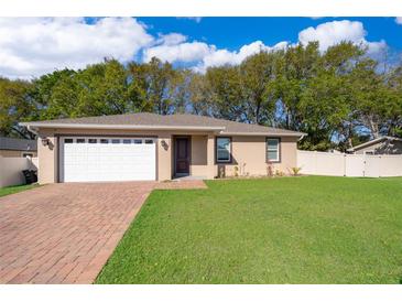 Charming single-story home featuring a brick driveway, manicured lawn, and an attached two-car garage at 248 Robin Rd, Altamonte Springs, FL 32701