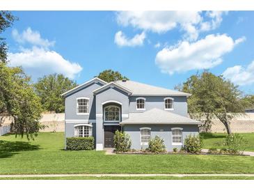 Charming two-story home featuring a well-manicured lawn and beautiful landscaping at 2581 Ponkan Summit Dr, Apopka, FL 32712