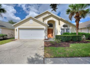 Charming single-story home featuring a manicured lawn, two-car garage, and inviting entryway at 2676 Emerald Island Blvd, Kissimmee, FL 34747