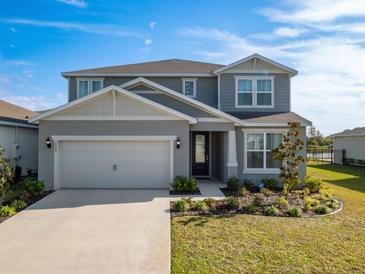 Charming two-story home featuring a manicured lawn and attached two-car garage at 2729 Timbergrove St, St Cloud, FL 34771