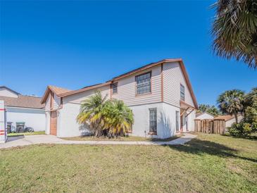 Charming two-story home with landscaped yard and architectural details under a clear blue sky at 7861 Copperfield Ct, Orlando, FL 32825