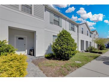 Charming townhouse with covered entry, landscaped yard, and neutral color scheme at 8907 Sydney Ave, Kissimmee, FL 34747