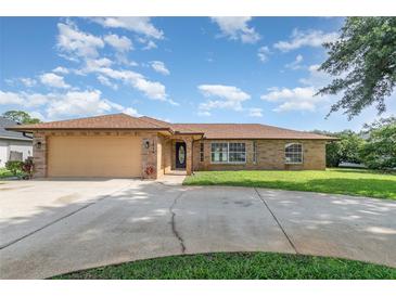 Charming single-story brick home with a well-manicured lawn and a spacious driveway at 1644 Piccadilly Dr, Daytona Beach, FL 32117