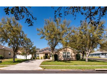 Charming single-story home with solar panels and a well-manicured lawn surrounded by mature trees at 2005 Blackbird Dr, Apopka, FL 32703