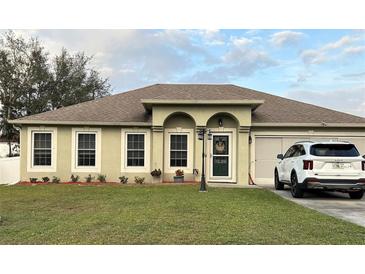 Charming single-story home with manicured lawn, arched entryway, and neutral color scheme with a newer car parked in the driveway at 203 Flounder Pl, Kissimmee, FL 34759