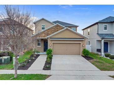 Charming two-story home with a stone facade, manicured landscaping, and a spacious two-car garage at 3320 Grande Heron Dr, Harmony, FL 34773