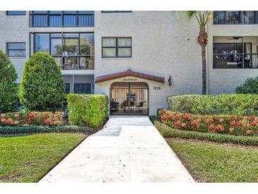 Andalucia condominium building entrance with lush landscaping and well-maintained walkway at 535 N Interlachen Ave # 107, Winter Park, FL 32789