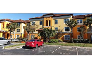 Charming condo building featuring a colorful facade, manicured landscaping, and assigned parking at 5479 Vineland Rd # 9104, Orlando, FL 32811