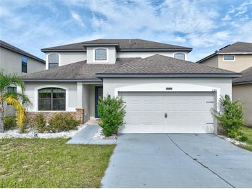 Charming two-story home with a manicured lawn, attached two-car garage, and beautiful landscaping at 625 Silverthorn Pl, Groveland, FL 34736
