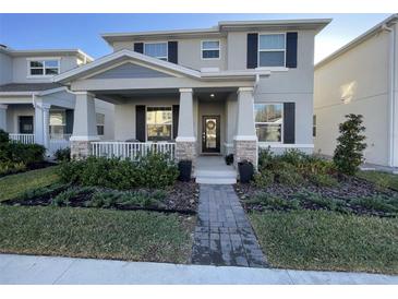 Charming two-story home featuring a welcoming front porch, manicured landscaping, and inviting curb appeal at 11137 Lore Way, Orlando, FL 32832