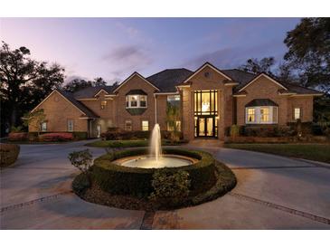 Stunning brick home with a circular driveway and a beautiful fountain feature in the front yard at 1500 Whitstable Ct, Lake Mary, FL 32746