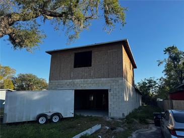 Unfinished exterior of new two story home featuring block construction and plywood walls against a blue sky at 3627 Lincoln St, Sanford, FL 32771