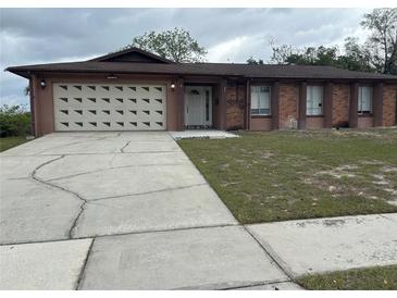 Charming single-story home with a two car garage and well-maintained landscaping and a cracked driveway at 6567 Magee Ct, Orlando, FL 32818