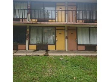 A two-story building featuring exterior walkways and colorful doors to individual units at 7900 S Orange Blossom Trl # 2052, Orlando, FL 32809