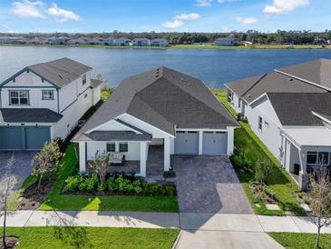 Beautiful single-Gathering home with a two-car garage, a well-manicured lawn, and stunning lake views at 13589 Mcmillan Dr, Orlando, FL 32827
