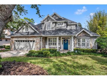 Charming two-story home with stone accents, a well-manicured lawn, and a bright blue front door at 1741 Pine Ave, Winter Park, FL 32789