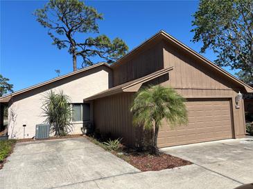 Inviting one story home featuring neutral stucco, wood paneling, well maintained landscaping, and an attached two-car garage at 250 Raintree Dr, Casselberry, FL 32707