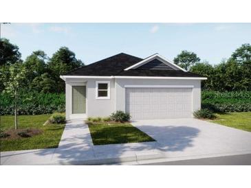 Charming single-story home featuring a two-car garage, a front lawn, and beautiful landscaping at 2735 San Marco Way, Winter Haven, FL 33884