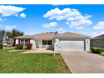 Charming single-story home features a well-manicured lawn and a two-car garage at 381 Corbett Dr, The Villages, FL 32162