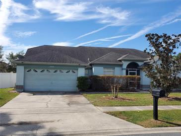 Charming single-story home features a well-maintained front yard and a two-car garage at 8630 Knottingham Dr, Kissimmee, FL 34747