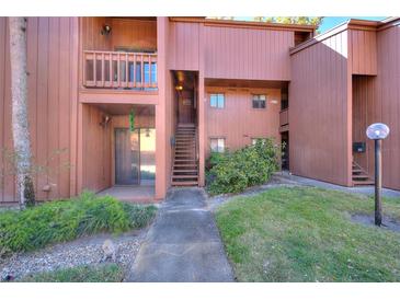 Exterior of the building with a staircase, balcony, and landscaped surroundings at 974 E Michigan St # 974, Orlando, FL 32806