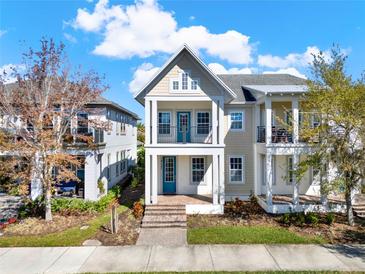 Charming two-story home featuring a double balcony, blue door, and manicured front lawn at 14137 Walcott Ave, Orlando, FL 32827