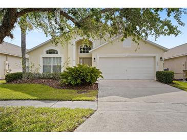 Inviting single-story home featuring lush landscaping and a two-car garage at 155 Barefoot Beach Way, Kissimmee, FL 34746