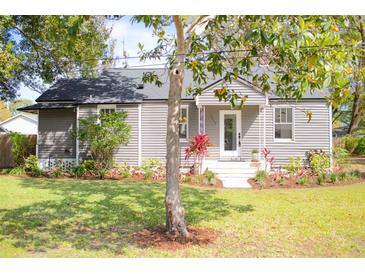 Charming home featuring manicured landscaping, a cozy porch and fresh, neutral paint at 1855 Cloverlawn Ave, Orlando, FL 32806