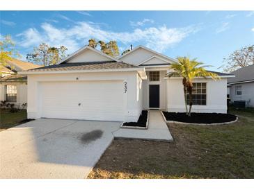 Charming single-story home featuring a well-maintained lawn and attached two-car garage at 237 Clarinet Way, Davenport, FL 33896