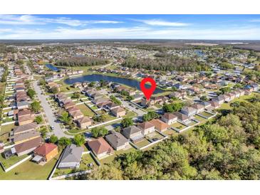 A beautiful aerial view showcases the lovely homes and community in this neighborhood with pond and trees at 4655 Ross Lanier Ln, Kissimmee, FL 34758