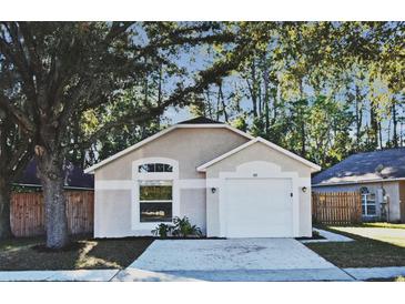 Charming single-story home with stucco facade, well-maintained landscaping, and attached one car garage at 107 Broadarrow Pl, Sanford, FL 32773
