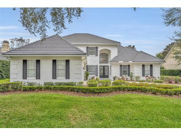 Beautiful two-story home features a manicured front lawn, a tile roof, and lush landscaping at 142 Stone Hill Dr, Maitland, FL 32751