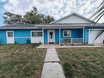 Charming single-story home with a blue exterior, white trim, front porch, and well-maintained lawn at 3243 Little Sound Dr, Orlando, FL 32827
