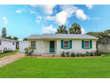 Charming single-story home with white exterior, teal shutters, and well-maintained lawn, perfect for coastal living at 476 Zelda Blvd, Daytona Beach, FL 32118