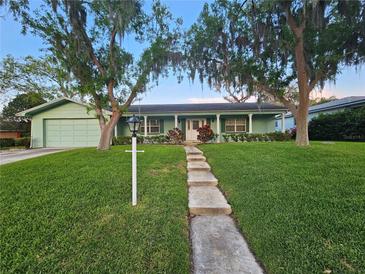 Charming home with green lawn and mature trees, complemented by a welcoming walkway to the front door at 805 Glen Arden Way, Altamonte Springs, FL 32701