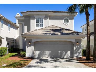 Charming two-story home featuring a tile roof, an attached two car garage, and meticulously maintained landscaping at 8426 Foxworth Cir # 44, Orlando, FL 32819