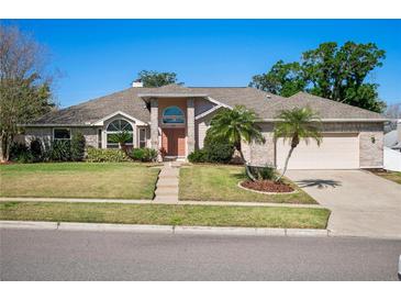Charming single-story home with brick accents, mature landscaping, and a well-manicured lawn at 907 Almond Tree Cir, Orlando, FL 32835