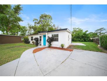 Exterior view of the home showcasing the well-manicured lawn and the front facade at 908 Cannes Pl, Orlando, FL 32808