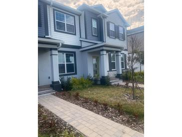 Attractive two-story townhome boasting a covered entry, well-manicured lawn, and tasteful exterior finishes at 9314 Bolshoi Aly, Winter Garden, FL 34787