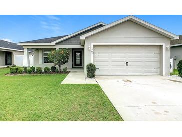Charming single-Gathering home featuring a well-manicured lawn, two-car garage, and inviting front entrance at 405 Bandon Dunes Loop, Davenport, FL 33837